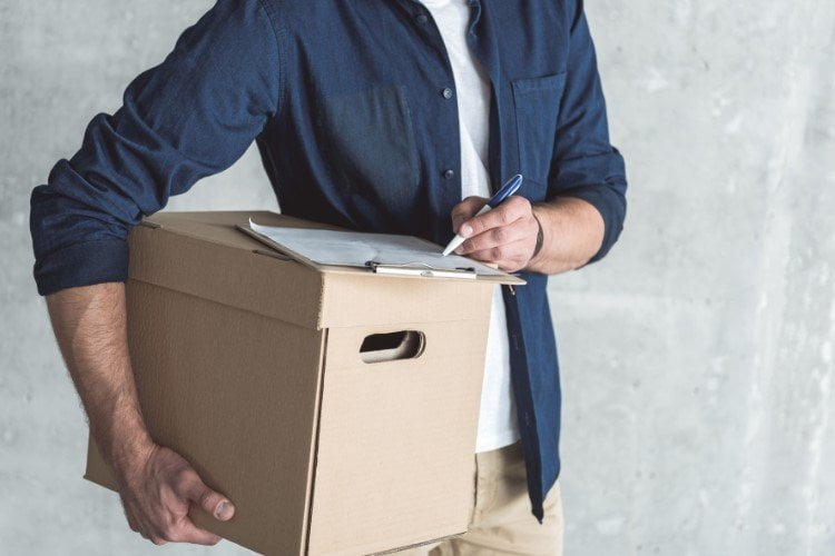 Professional messenger male is carrying parcel